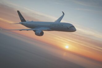 Image shows a Cathay Pacific A350-900 aircraft flying in a sunset