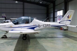 The blue and white B-12 PP plane, a Sunward Aurora SA60L, that would later be crashed by Liu, sat in a well-lit aircraft hanger.
