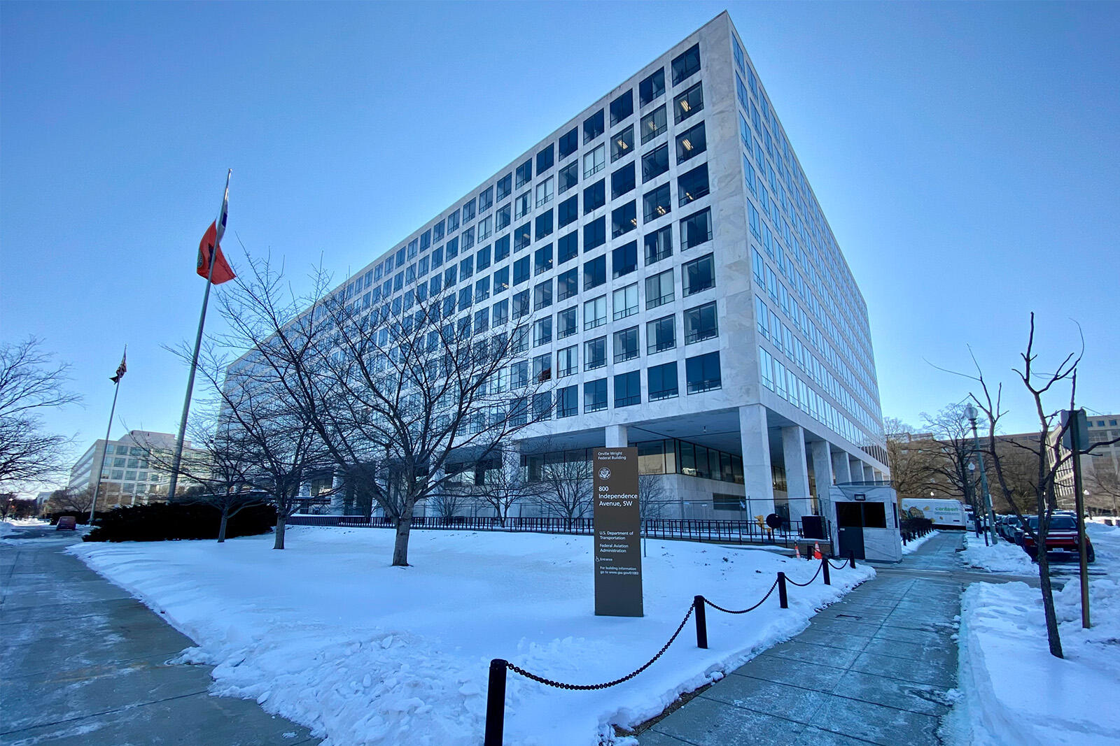 The headquarters of the Federal Aviation Administration (FAA) in Washington on a snowy day, in front of a clear blue sky.