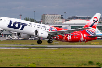 A LOT Polish Airlines Boeing 737 about to take off from a runway.