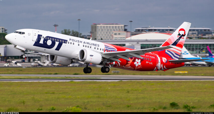 A LOT Polish Airlines Boeing 737 about to take off from a runway.