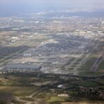 An aerial picture of London Heathrow. One can see all different terminals and the planes parked outside the gates. The runways are also visible