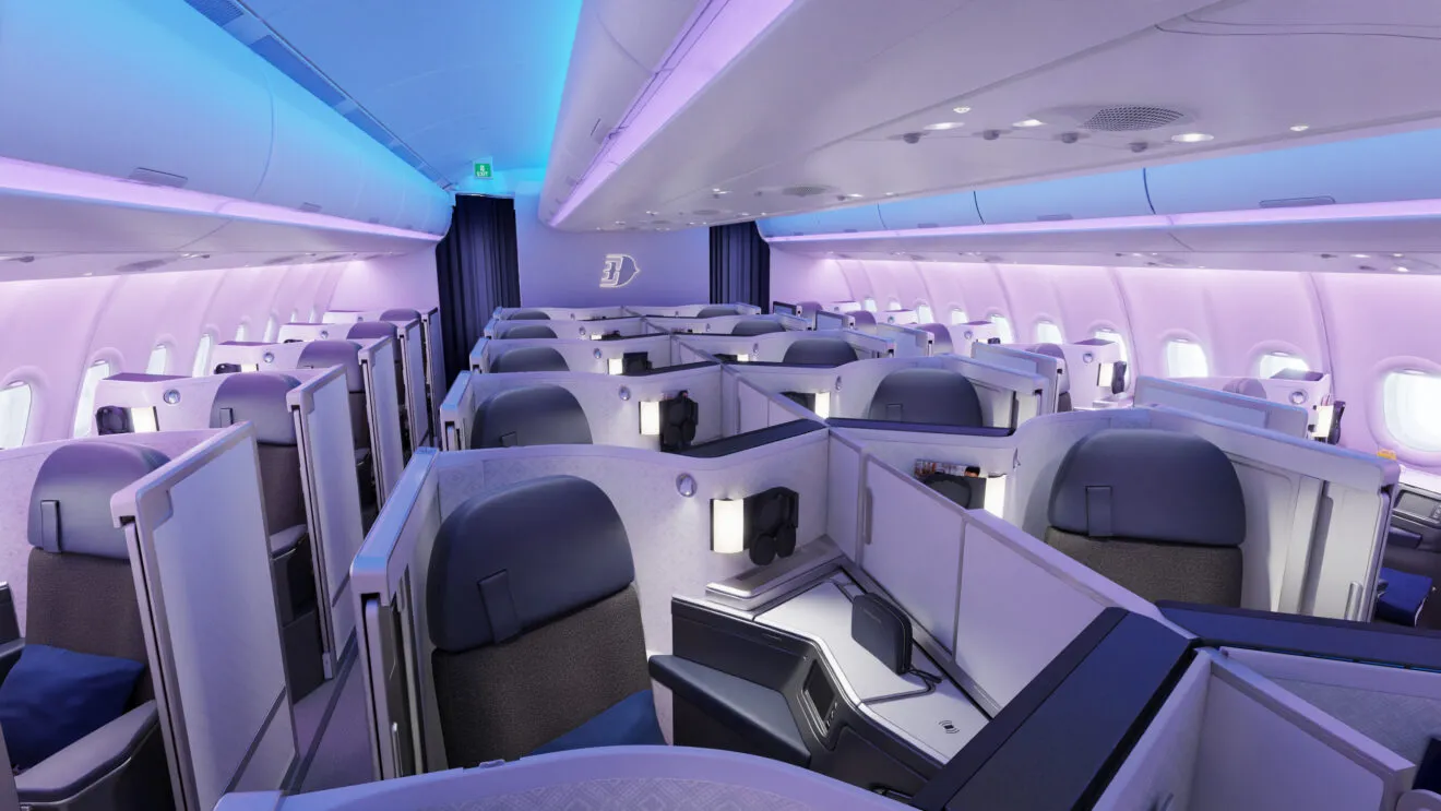 Aeroplane cabin Business class view from interior, with cabin light streaks blue and pink and daylight coming through the windows.
