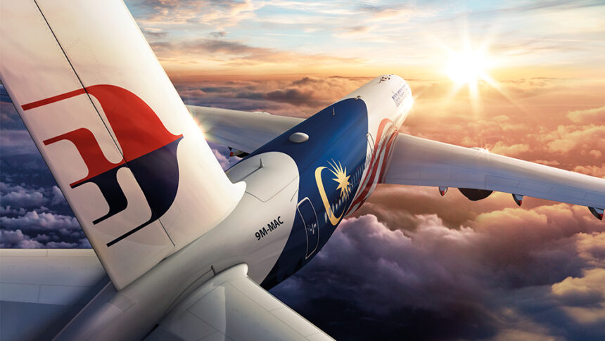 An aircraft flying into a golden sunset, with fluffy clouds below.