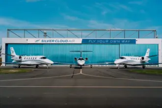 Silver Cloud Air building in the background with three aircraft in view; one in the centre and one either side of it. Blue sky in the background.