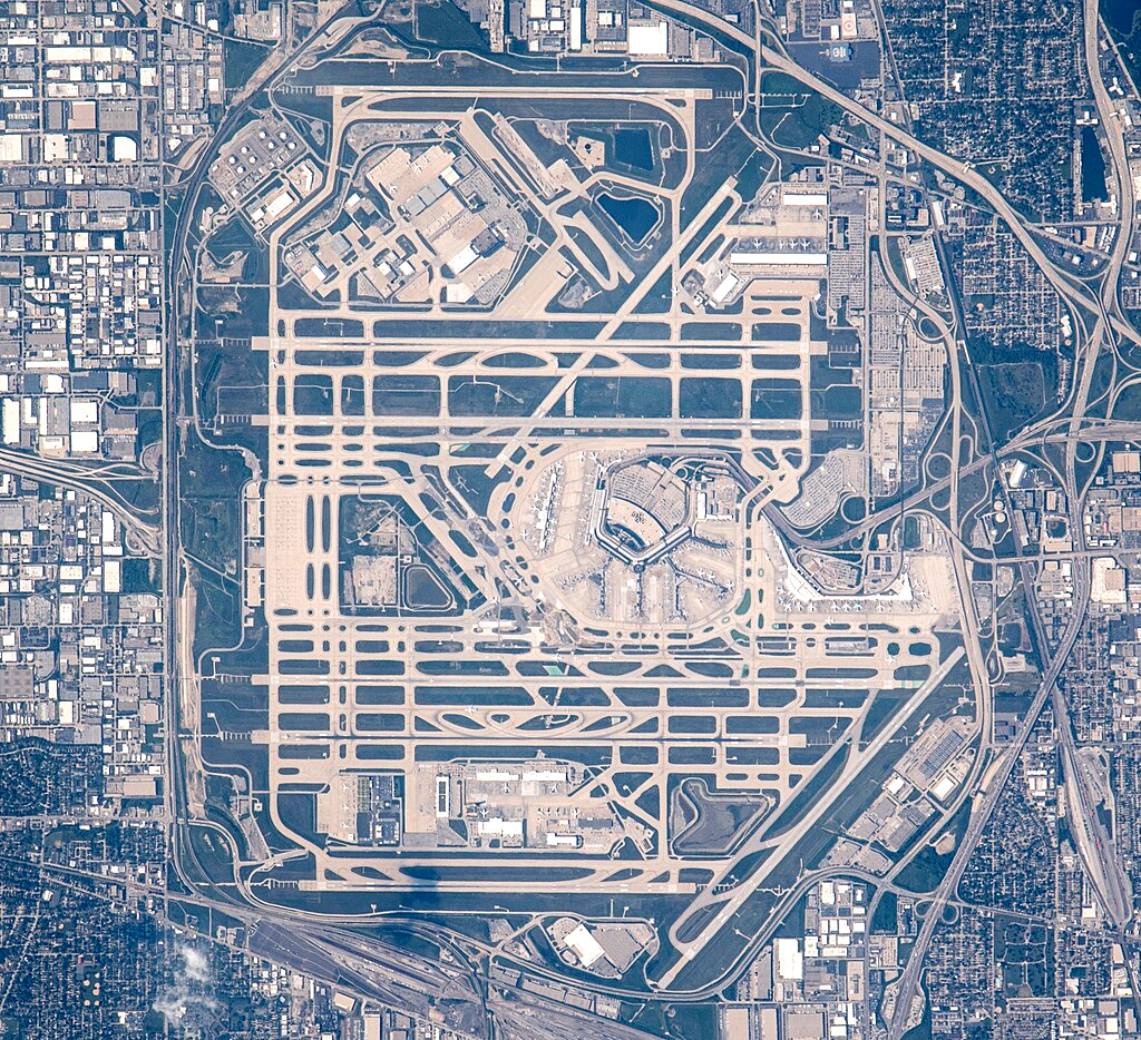 O'Hare International Airport seen from above, as the picture was taken from the International Space Station. There are several straight lines (the runways) and one large circle (the airport).