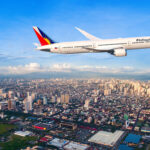 Philippine Airlines 787-9 flying above Manila City with blue sky in the background