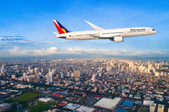 Philippine Airlines 787-9 flying above Manila City with blue sky in the background