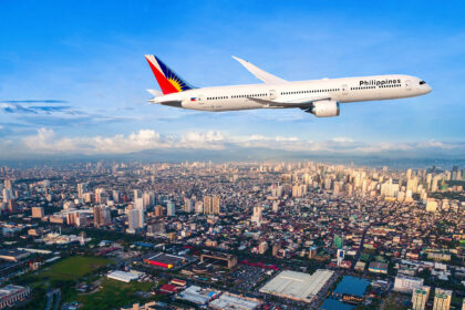 Philippine Airlines 787-9 flying above Manila City with blue sky in the background