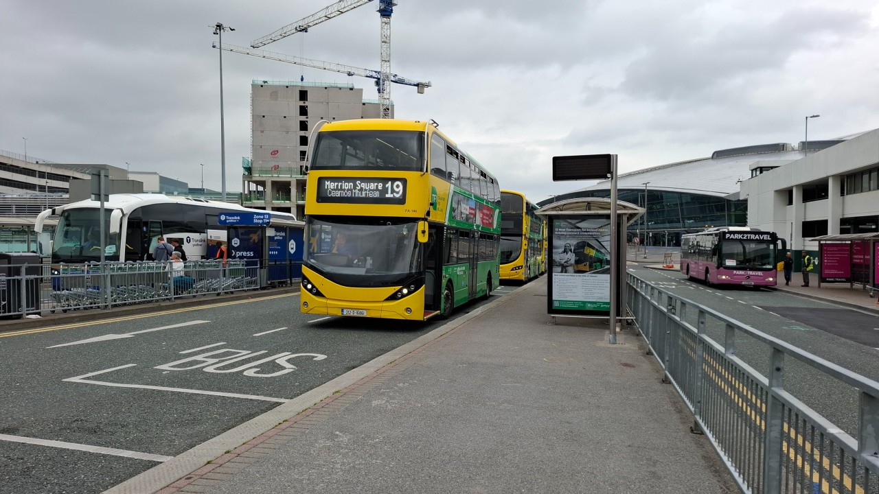 A yellow route 19 Bus waits for passengers outside of Dublin Airport.