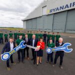 Ryanair and Shannon Airport Group Posing with signs shaped like spanners outside the existing Ryanair hangar at Shannon Airport.