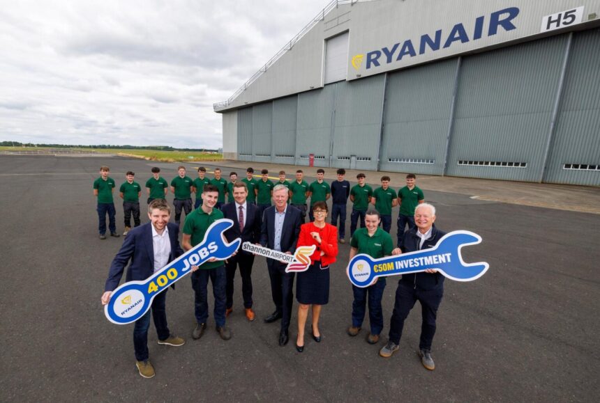 Ryanair and Shannon Airport Group Posing with signs shaped like spanners outside the existing Ryanair hangar at Shannon Airport.