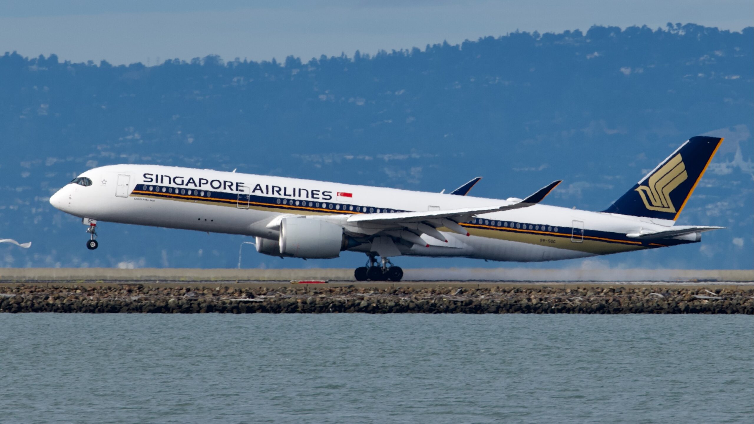 Full length side view of Singapore Airlines' A350-900ULR beginning to take off with only its front wheel off the ground.