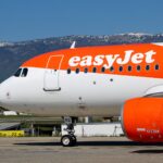 Side view of the front half of an Airbus A320 aircraft operated by easyJet on the ground.