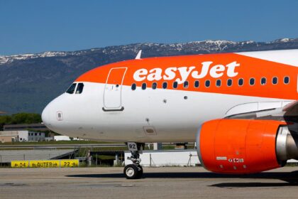 Side view of the front half of an Airbus A320 aircraft operated by easyJet on the ground.