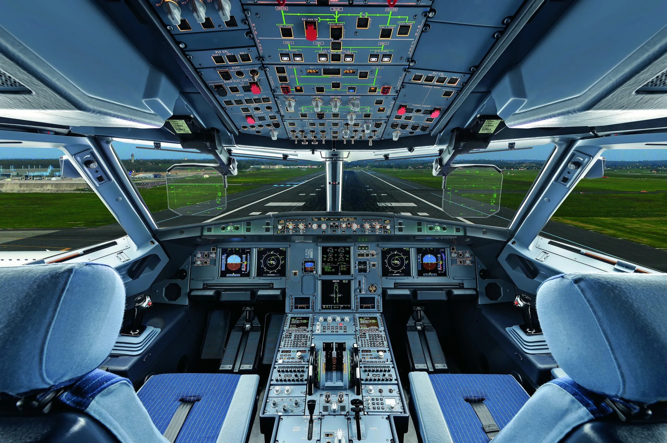Image of the interior cockpit in an Airbus A320. Pilot seats and controls can be seen.