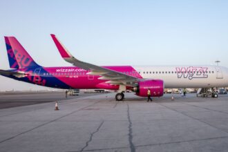 A side view of a Wizz Air a321-neo-7 plane waiting on the tarmac