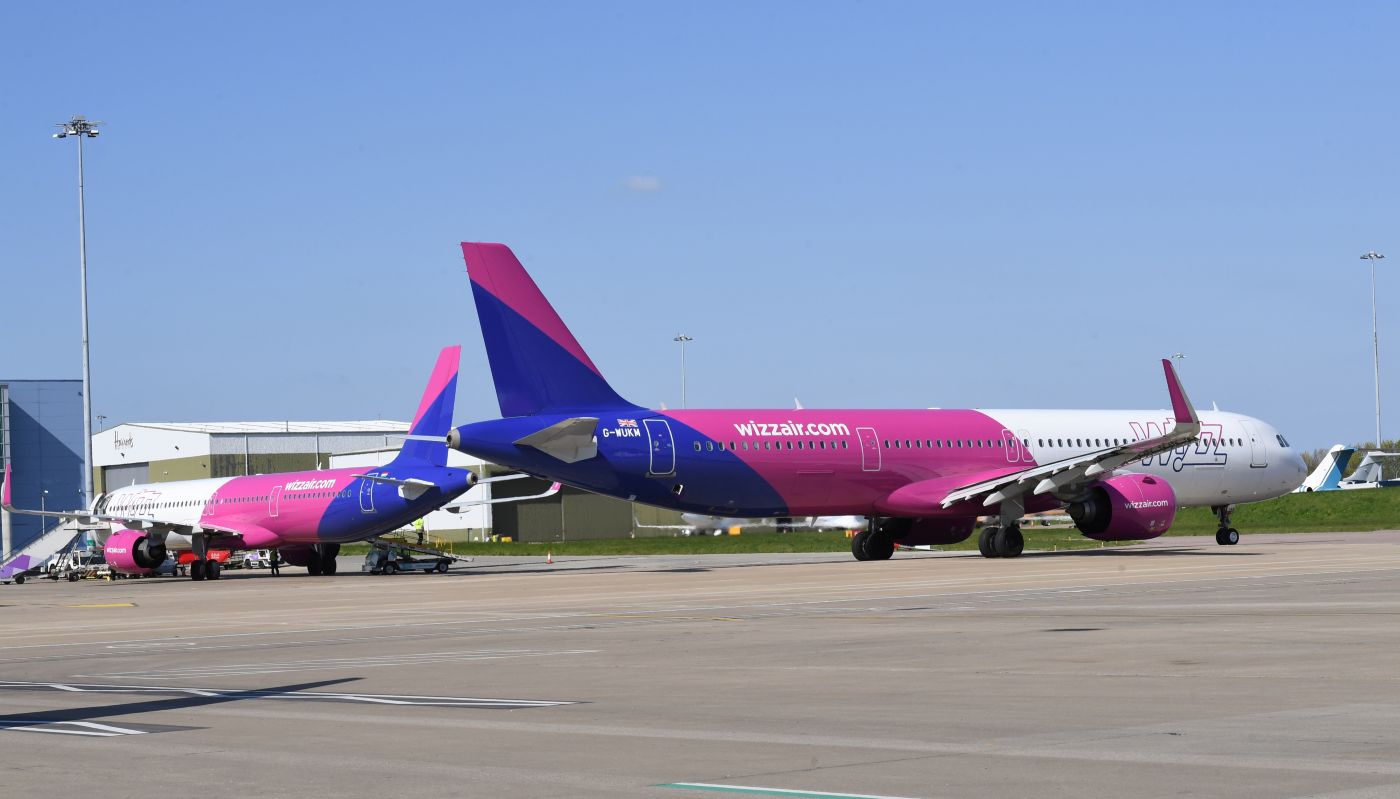 A rerview of two Wizz Air a321-neo-7 planes waiting on tarmac with a clear blue sky backdrop