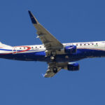 An Air Peace plane mid-flight, showing the bottom of the plane's fuselage and underside of its wings.