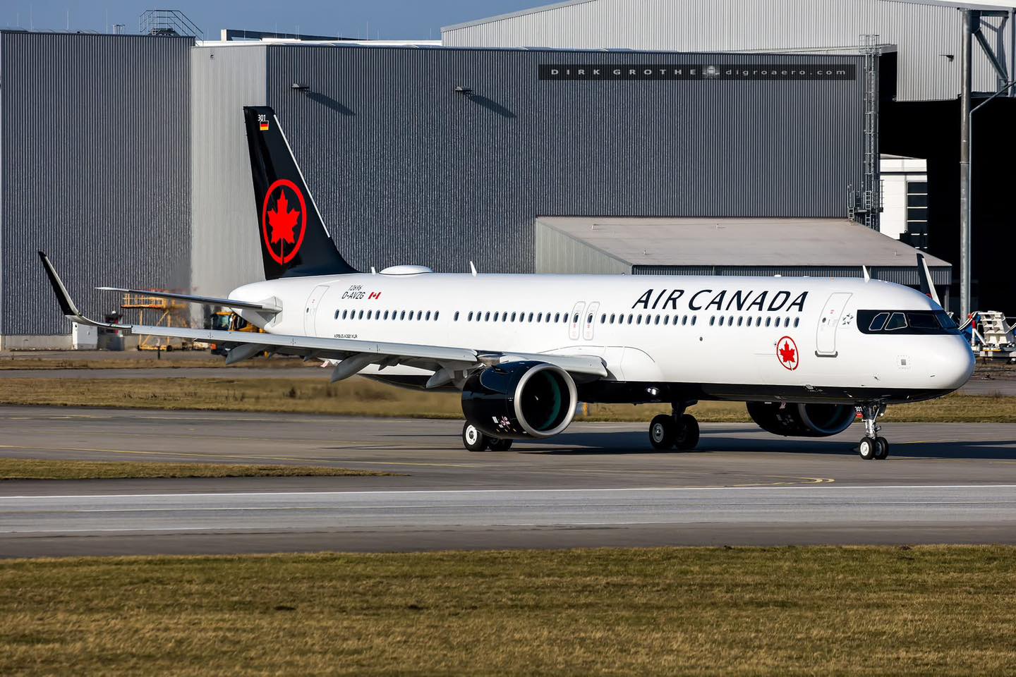 Air canada Airbus A321XLR taxiing on the runway sideways view with airport buildings in the background
