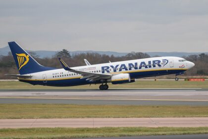 A Ryanair Boeing 737 that has landed and is parked on an airport runway.