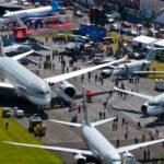 Birds Eye view of Farnborough airshow with multiple aircraft positioned on the ground for people to walk in and explore around