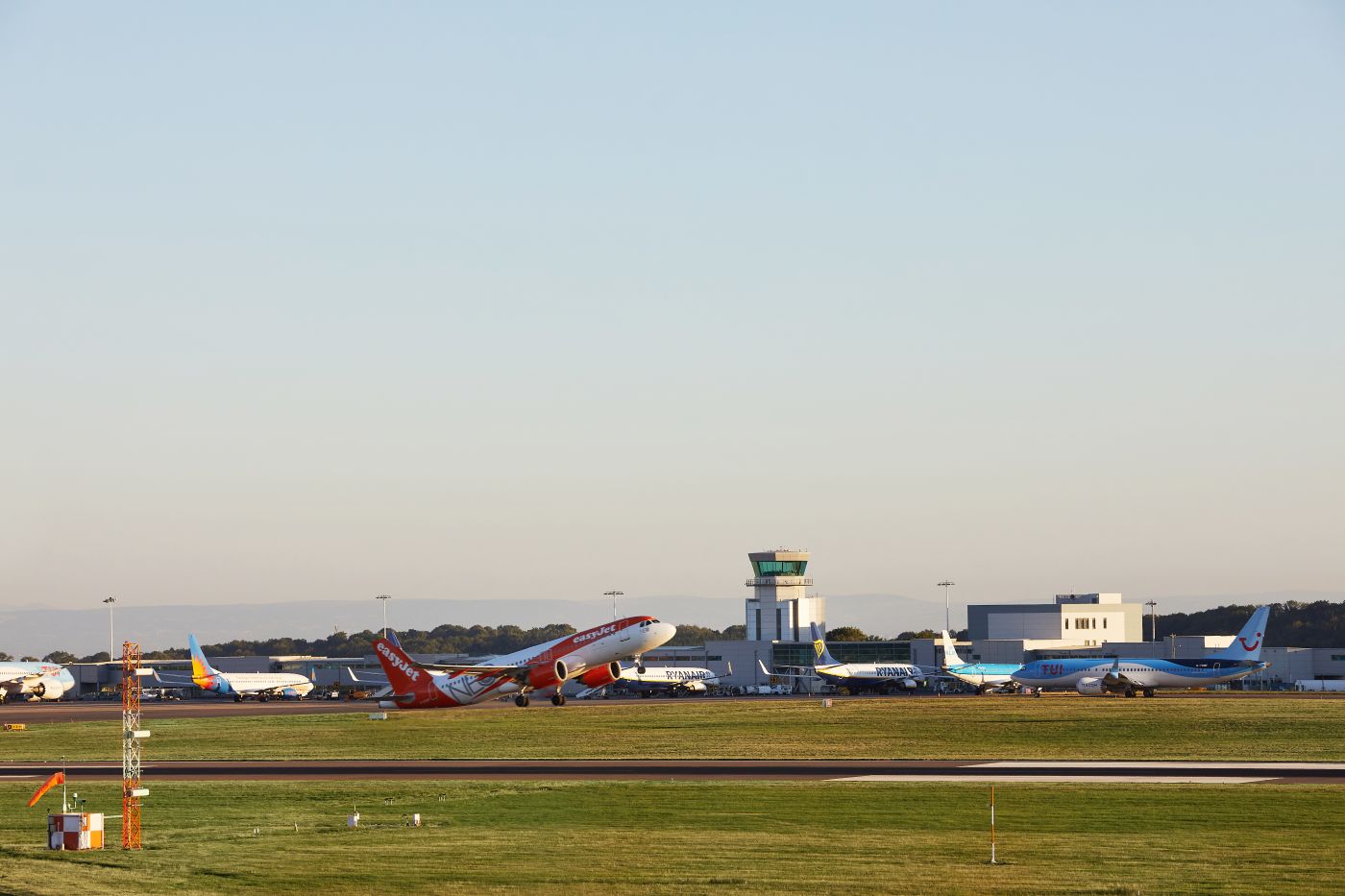 EasyJet planes at Bristol Airport Tarmac surrounded by grass and a clear blue sky