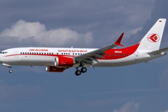 Air Algérie Boeing 737 MAX 8, registered D-AVOL, in flight against a cloudy sky.
