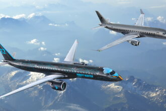 two black Embraer aircraft flying side by side above the clouds
