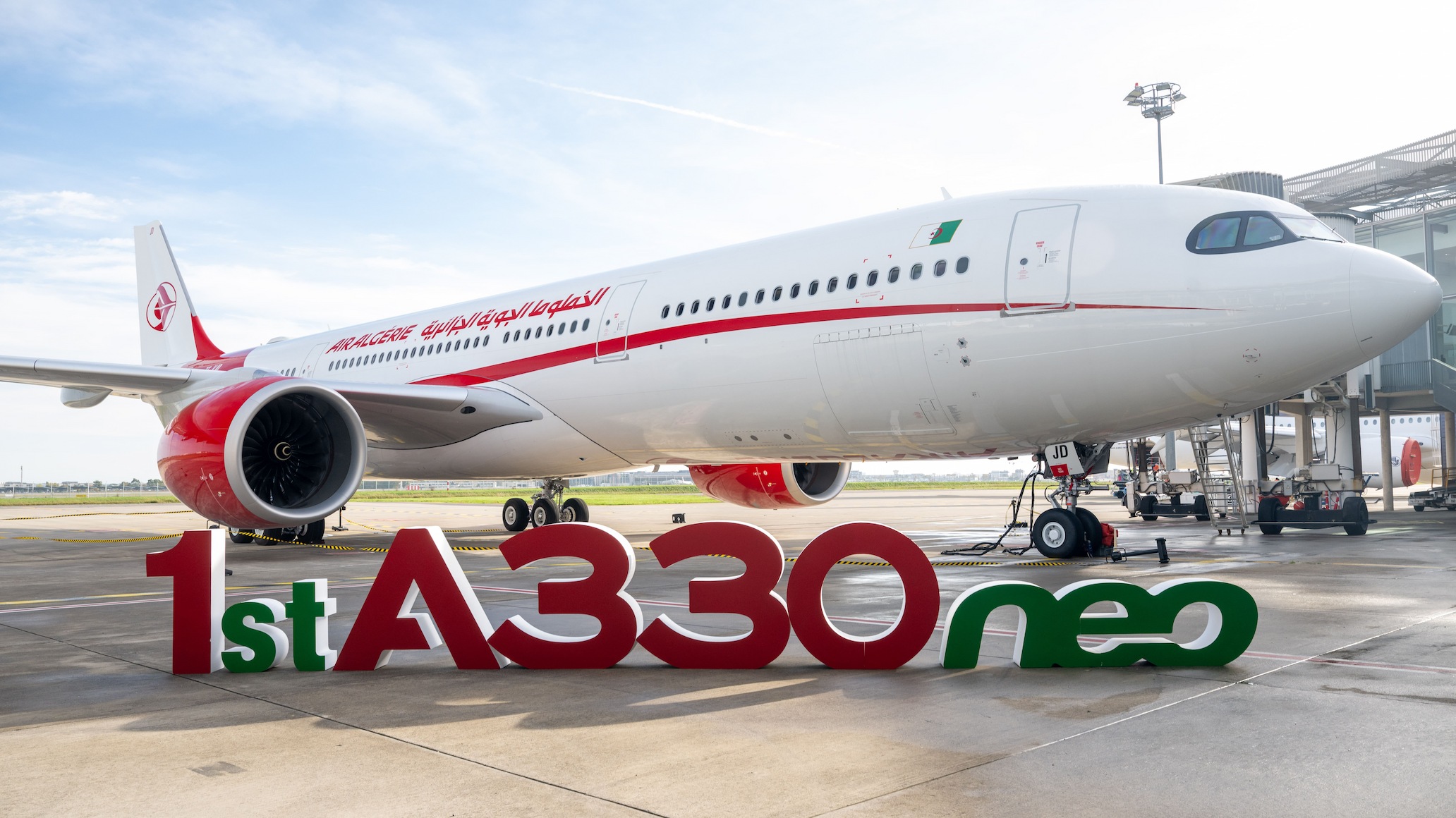 Air Algérie's first Airbus A330-900neo parked at the gate with a "1st A330neo" sign in front of it.