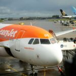 A front view of an easyJet aircraft waiting on tarmac with another airplane in the background.