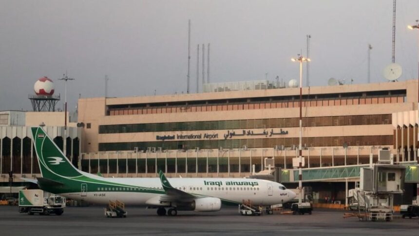An Iraqi Airways jet on the apron at Baghdad International Airport with airport buildings visible in the background