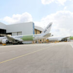 Two Boeing 777-300ERSF converted freighter aircraft, in Kalitta Air and AerCap Cargo liveries, parked outside an IAI Aviation Group hangar.