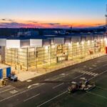 nighttime outside view of the new terminal with bright lights shining from the windows