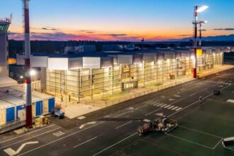 nighttime outside view of the new terminal with bright lights shining from the windows