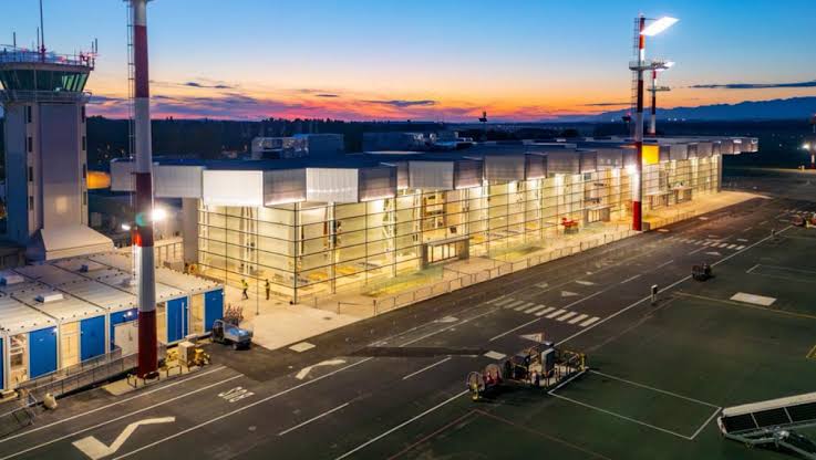 nighttime outside view of the new terminal with bright lights shining from the windows