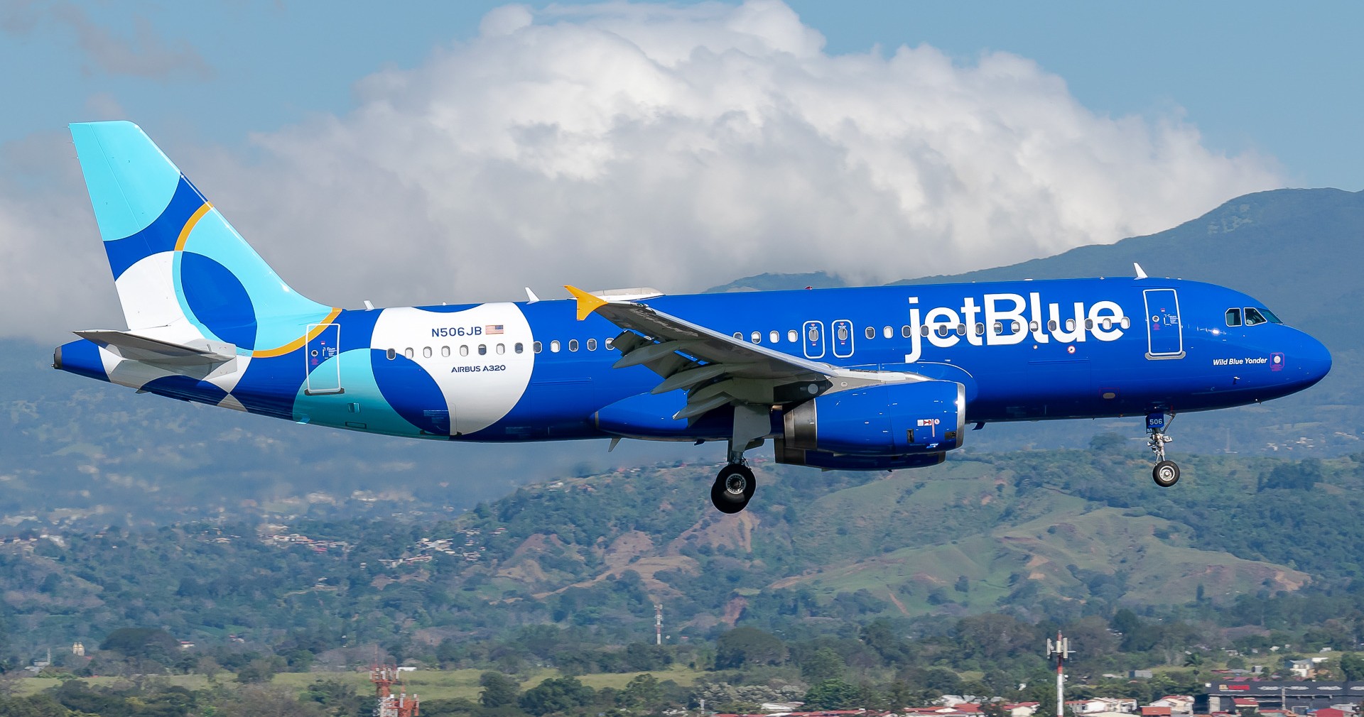 JetBlue Airbus A320-232 registered N506JB in special livery on approach with mountains in the background.