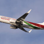 A Royal Air Maroc Boeing 737 mid-flight with a blue sky in the background.