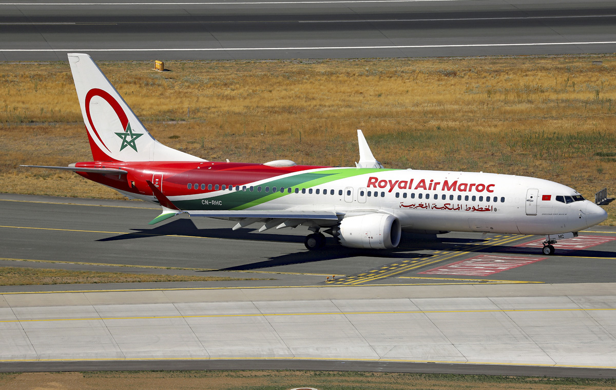 A Royal Air Maroc B737 sat on a tarmac runways, with grass just behind.