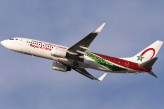 A Royal Air Maroc Boeing 737 mid-flight with a blue sky in the background.