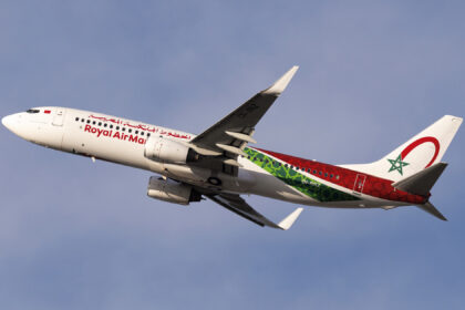 A Royal Air Maroc Boeing 737 mid-flight with a blue sky in the background.