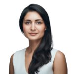 Zahidi front facing shot with a white background and she is wearing a white top.
