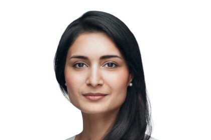 Zahidi front facing shot with a white background and she is wearing a white top.
