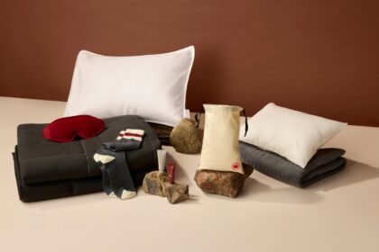 The signature class amemity kit laid out on a surface. Featuring pillow, duvet, eye mask, socks and skincare products.