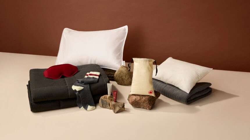 The signature class amemity kit laid out on a surface. Featuring pillow, duvet, eye mask, socks and skincare products.