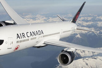 Exterior view of Air Canada aircraft cruising above the clouds.