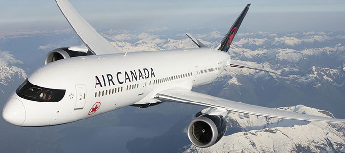 Exterior view of Air Canada aircraft cruising above the clouds.