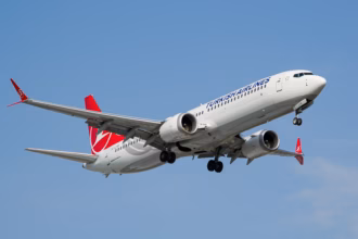 A Boeing 737 Max 9 flying on blue sky, the new moving assembly line replicates Boeing's existing 737 production system used at its Renton factory