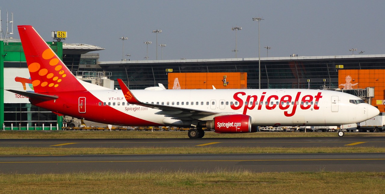 SpiceJet Boeing 737-8AS (VT-SLF) taxiing at an airport, showing the airline's red and white livery.