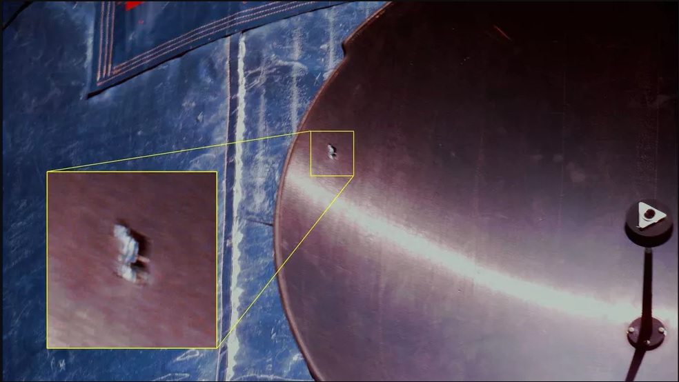 A chip due to debris damage to the outer edge of the parabolic antenna dish on the Hubble Space Telescope.